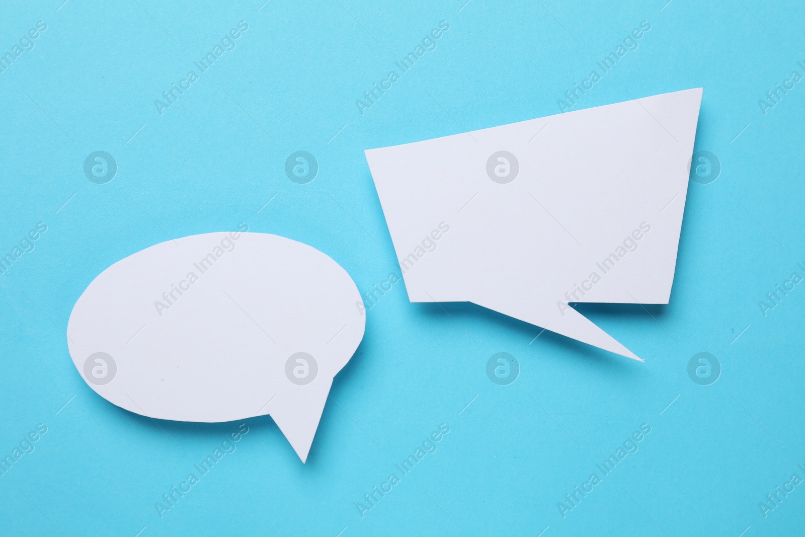 Photo of Blank speech bubbles on light blue background. Space for text