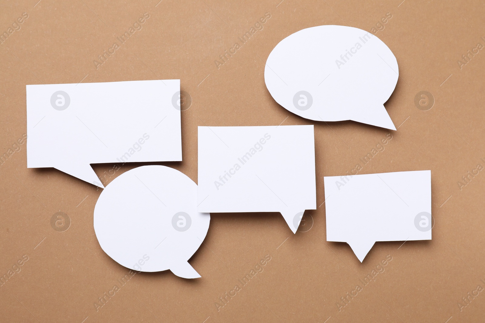 Photo of Blank speech bubbles on brown background. Space for text