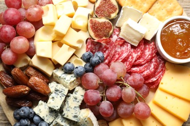 Photo of Different types of delicious cheese and other snacks on table, top view