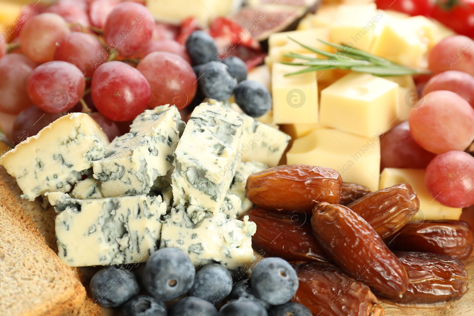 Photo of Different types of delicious cheese and other snacks as background, closeup