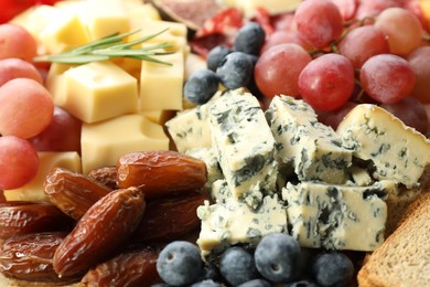 Photo of Different types of delicious cheese and other snacks as background, closeup