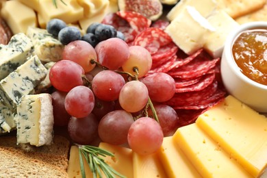 Photo of Different types of delicious cheese and other snacks as background, closeup