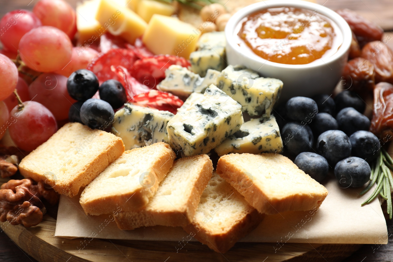 Photo of Different types of delicious cheese and other snacks on table, closeup