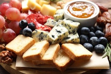 Photo of Different types of delicious cheese and other snacks on table, closeup