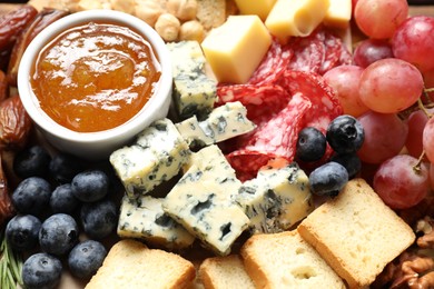 Photo of Different types of delicious cheese and other snacks as background, above view