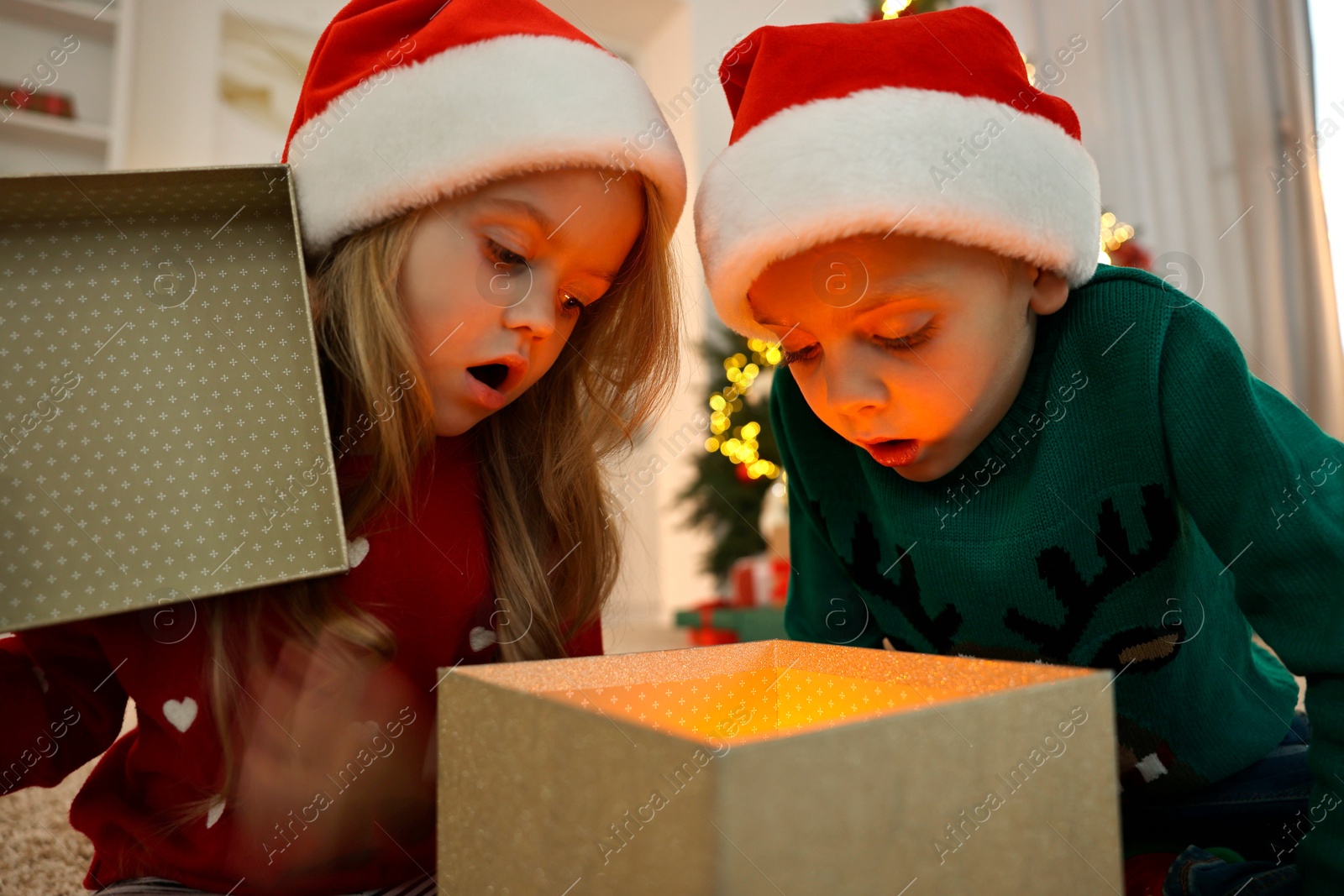 Photo of Little kids opening magic Christmas box at home