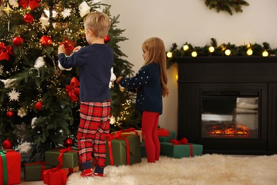 Little kids decorating Christmas tree at home