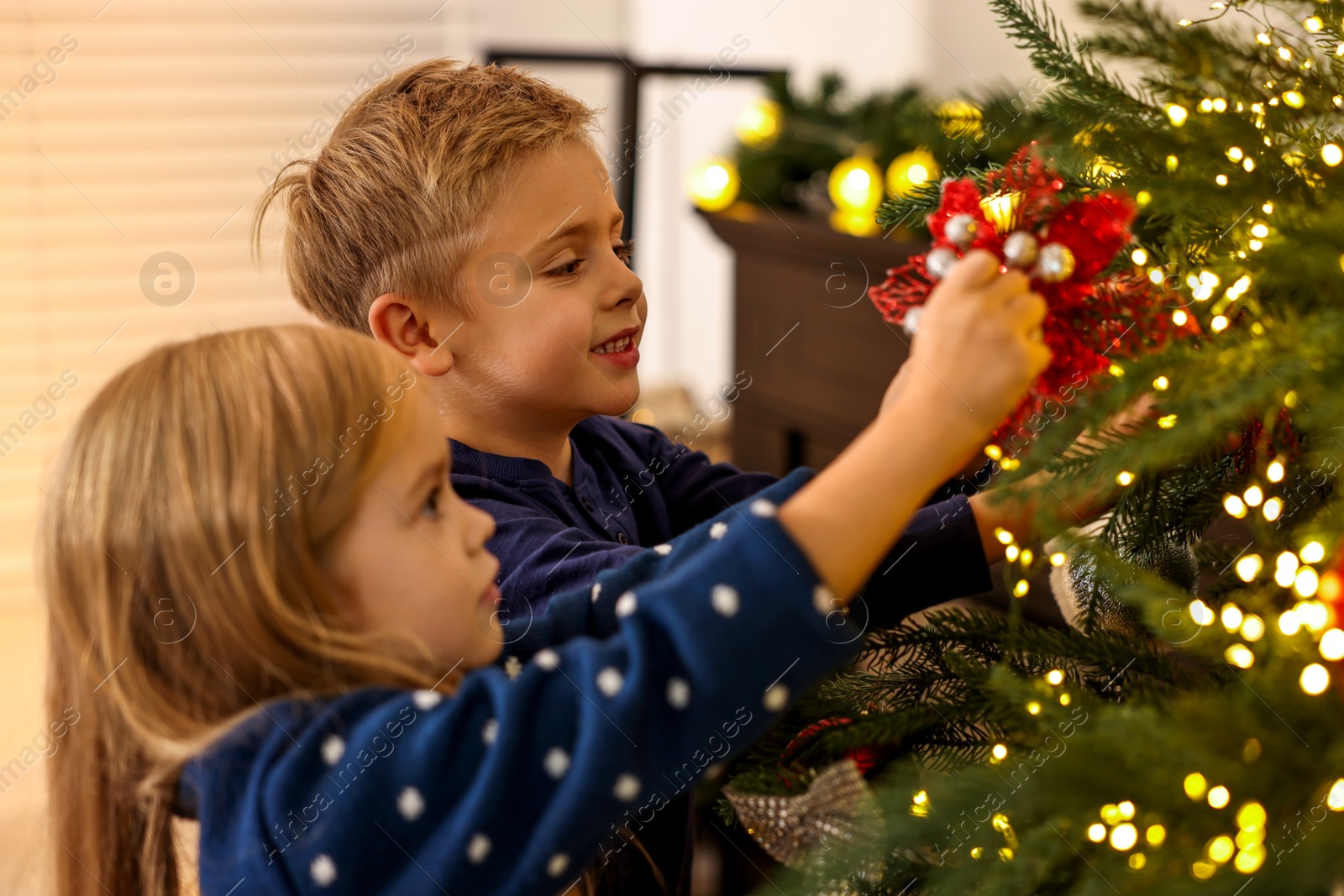 Photo of Little kids decorating Christmas tree at home