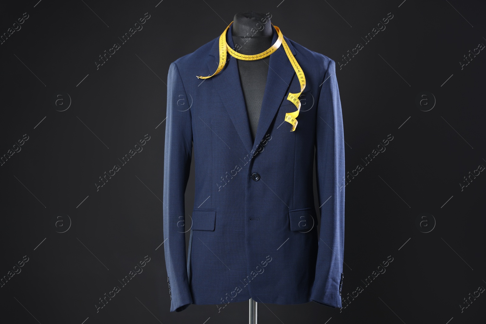 Photo of Male mannequin with jacket and measuring tape on dark background