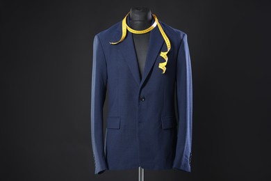 Photo of Male mannequin with jacket and measuring tape on dark background