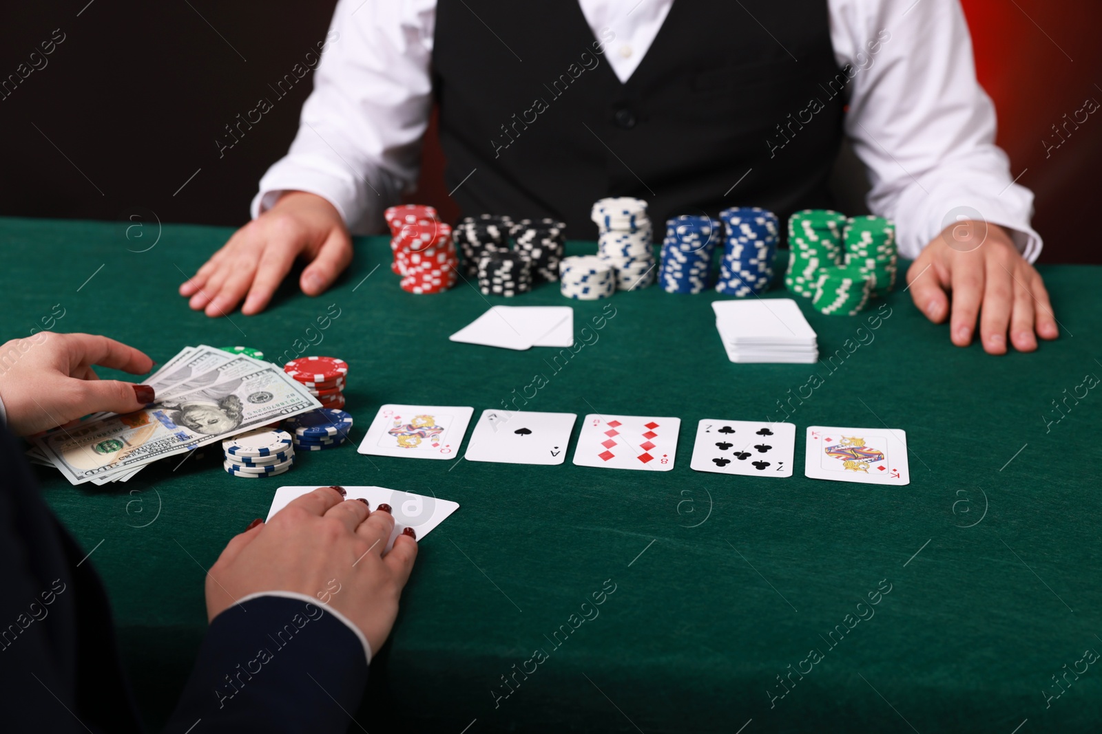 Photo of Gambler making bet with professional croupier at gambling table, closeup