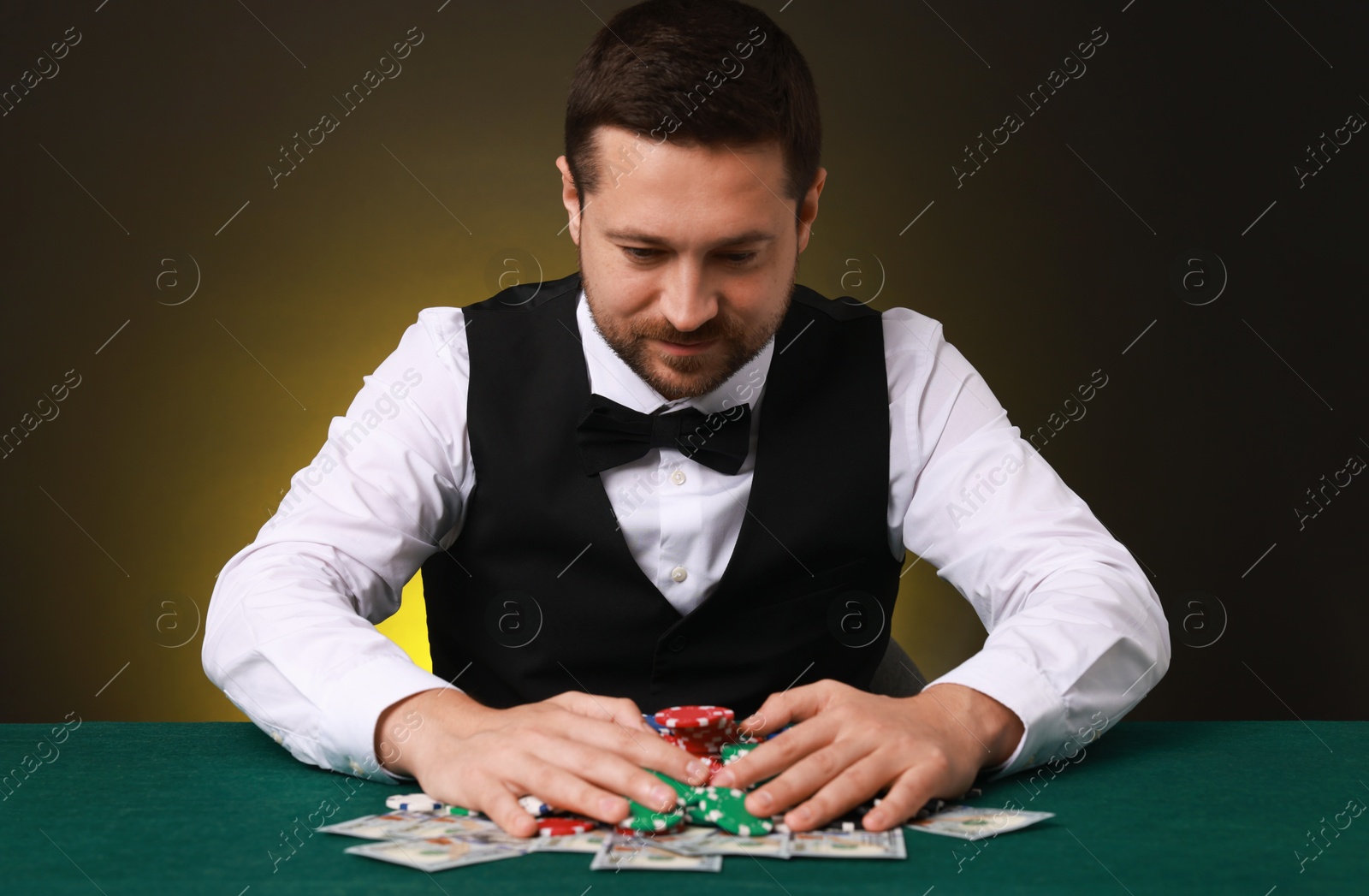 Photo of Professional croupier accepting bets at gambling table