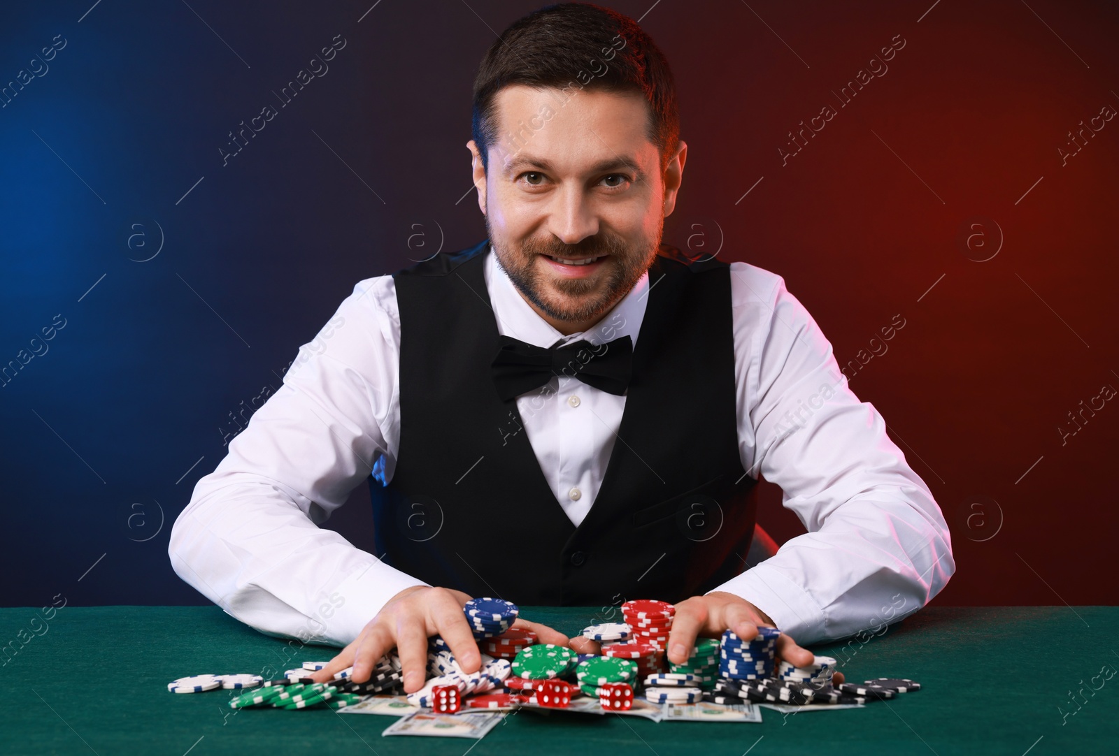 Photo of Professional croupier accepting bets at gambling table