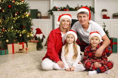 Portrait of happy family in Santa hats at home. Christmas holidays