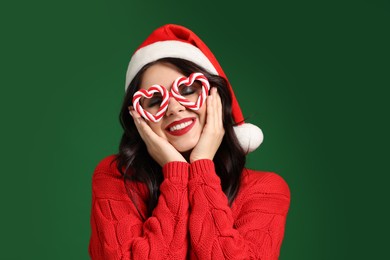 Photo of Beautiful woman in Santa hat and party glasses on green background. Christmas celebration