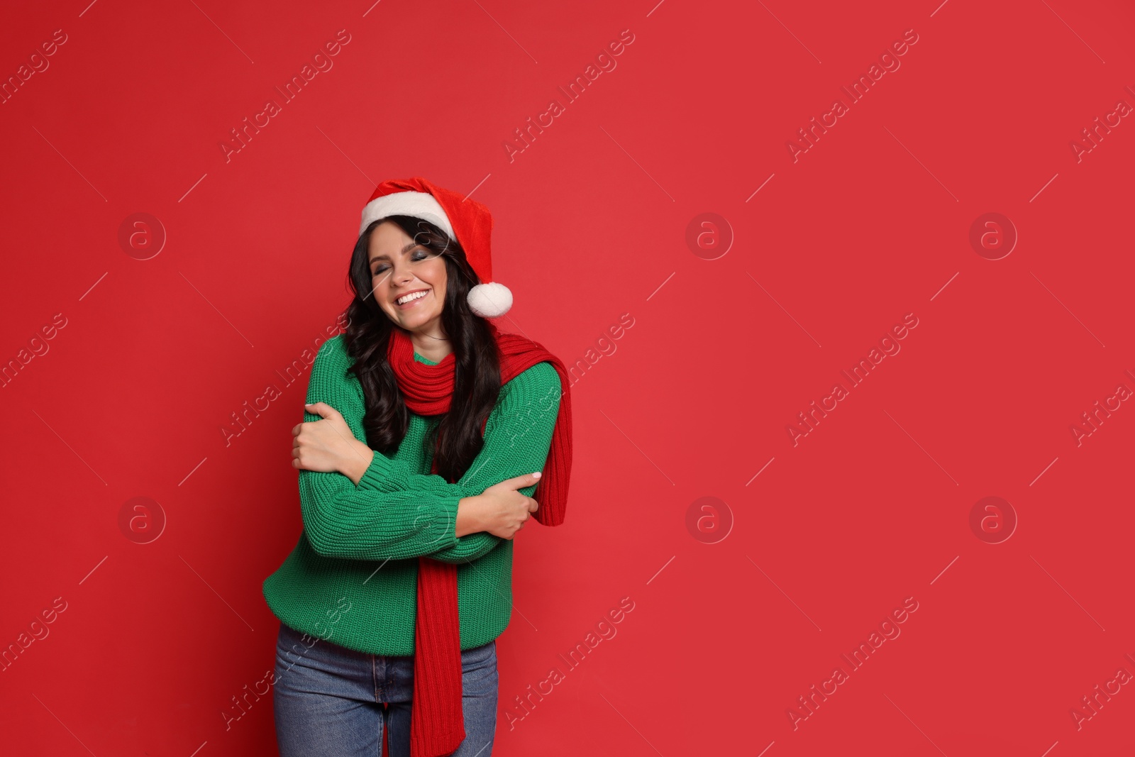 Photo of Beautiful woman in Santa hat on red background, space for text. Christmas celebration