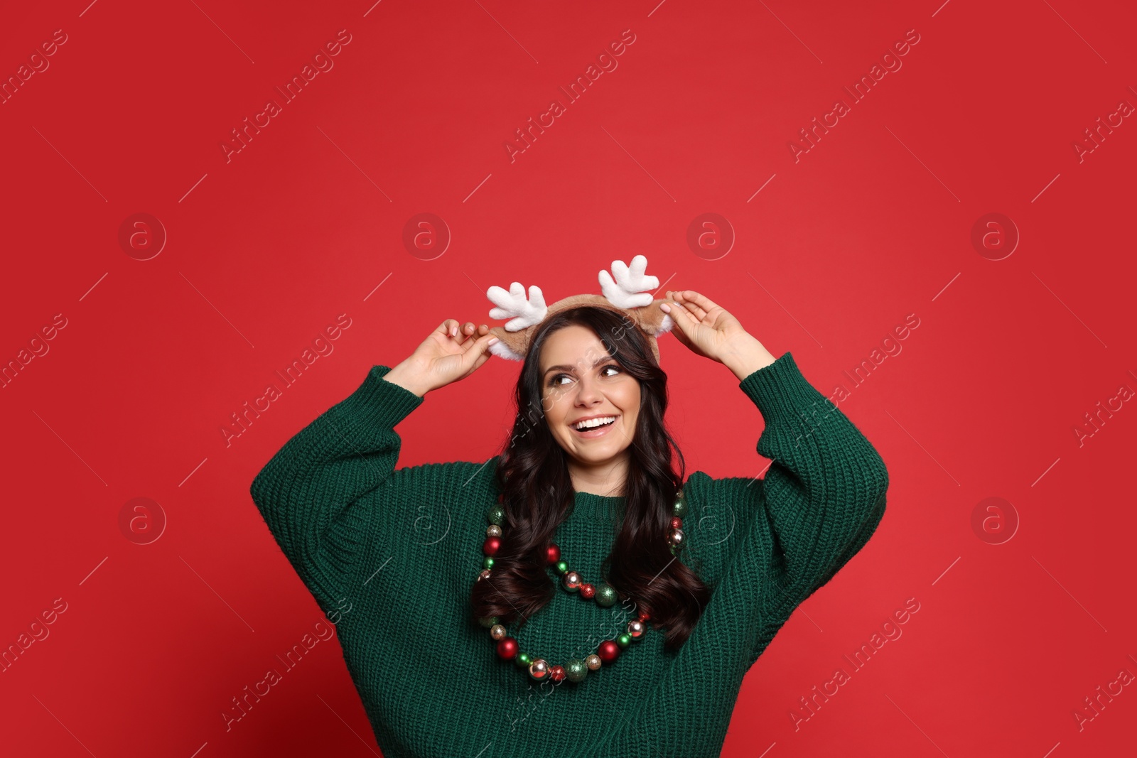 Photo of Beautiful woman with Christmas accessories on red background