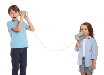 Photo of Boy and girl talking on tin can telephone against white background