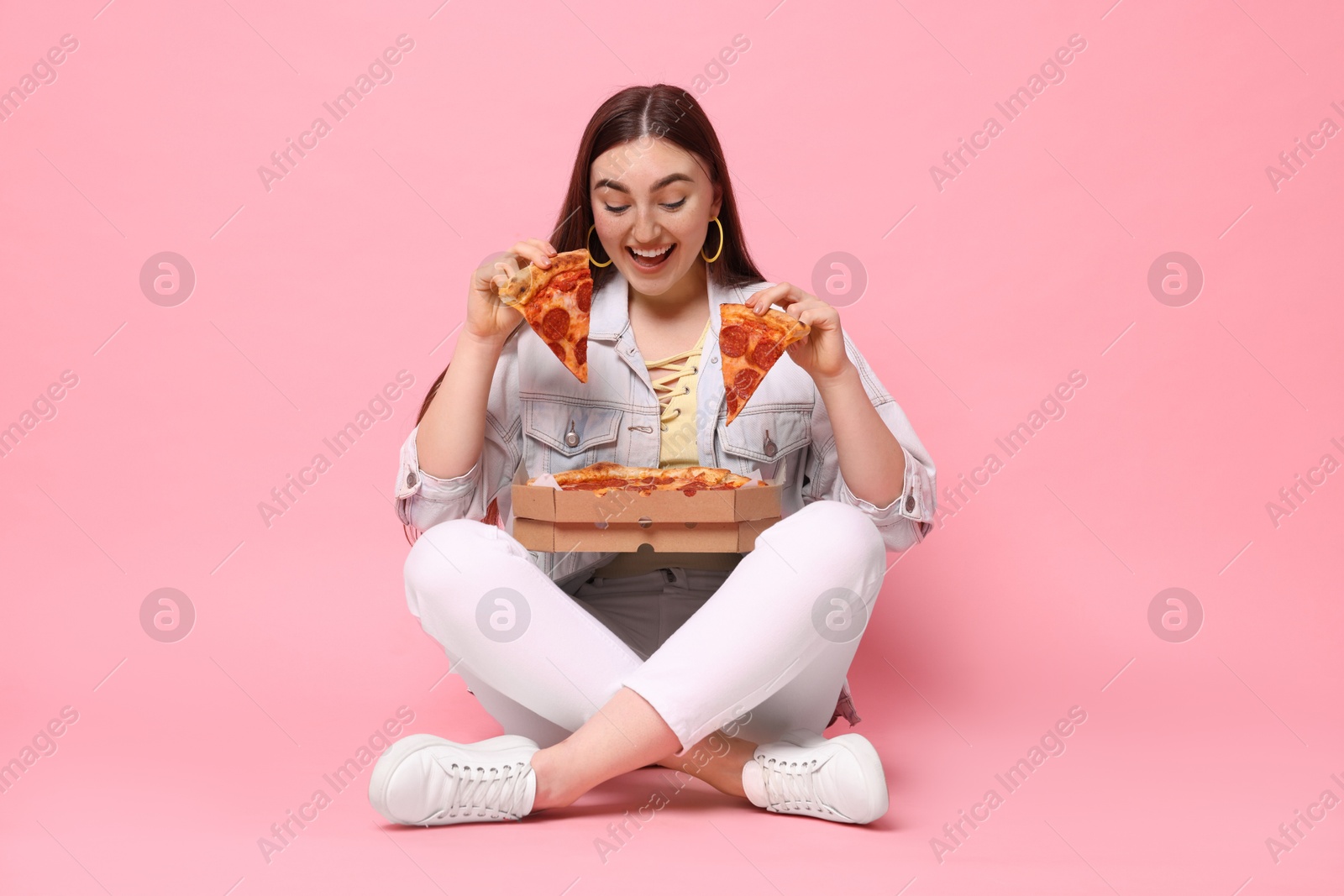 Photo of Beautiful woman with delicious pizza on pink background