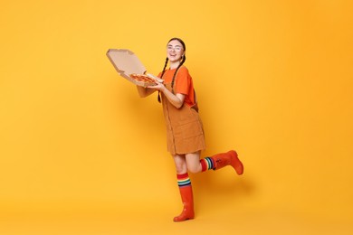 Photo of Beautiful woman with delicious pizza on orange background