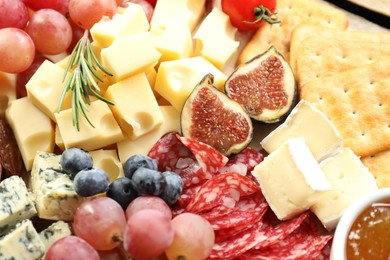 Photo of Different types of delicious cheese and other snacks as background, closeup