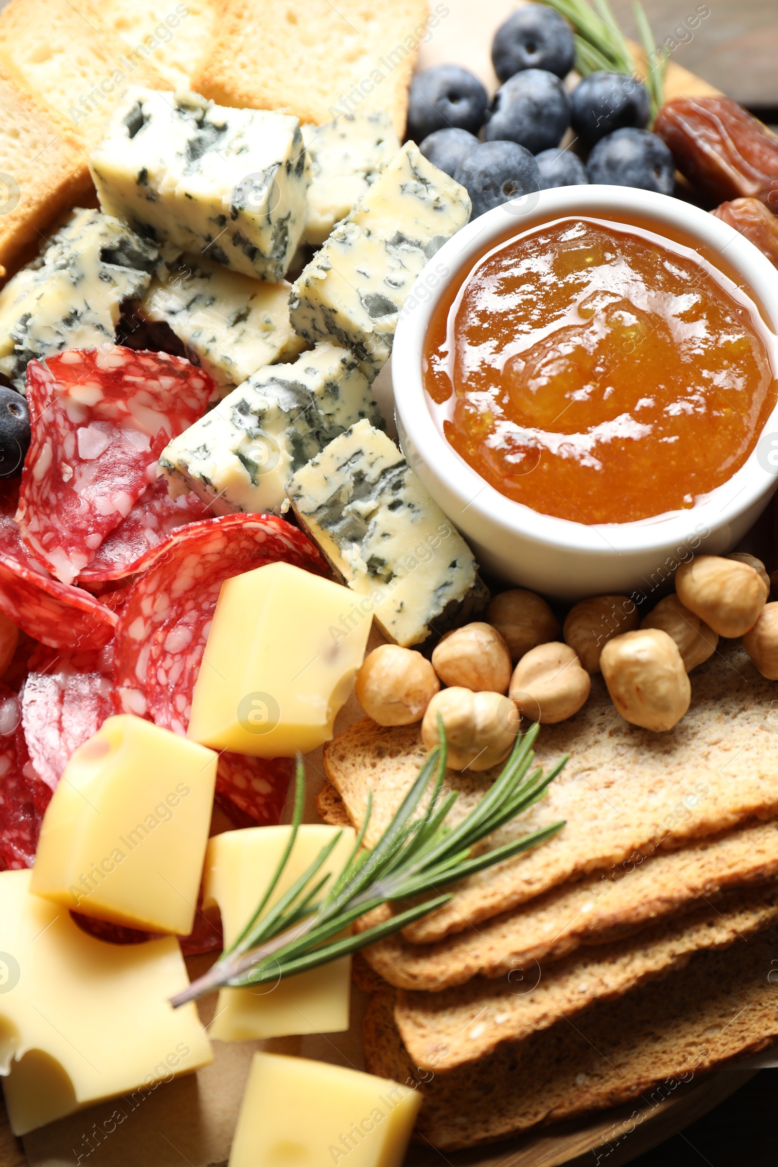 Photo of Different types of delicious cheese and other snacks on table, closeup