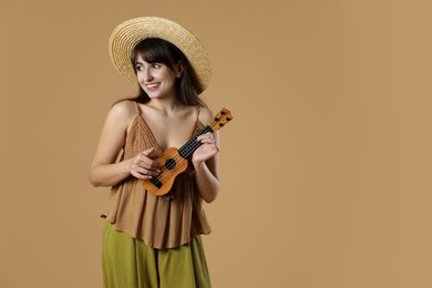 Photo of Happy woman playing ukulele on beige background, space for text