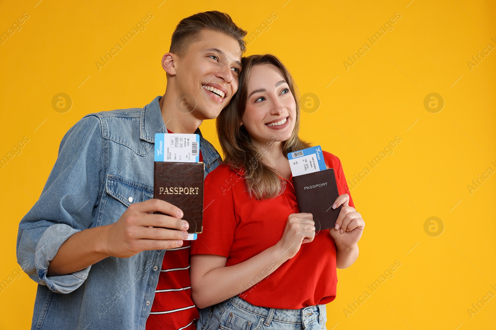 Photo of Happy travellers with passports and tickets on yellow background. Space for text