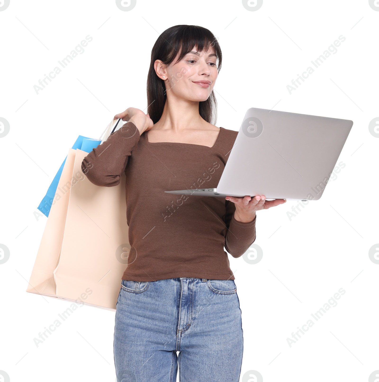 Photo of Internet shopping. Beautiful woman with laptop and colorful bags on white background