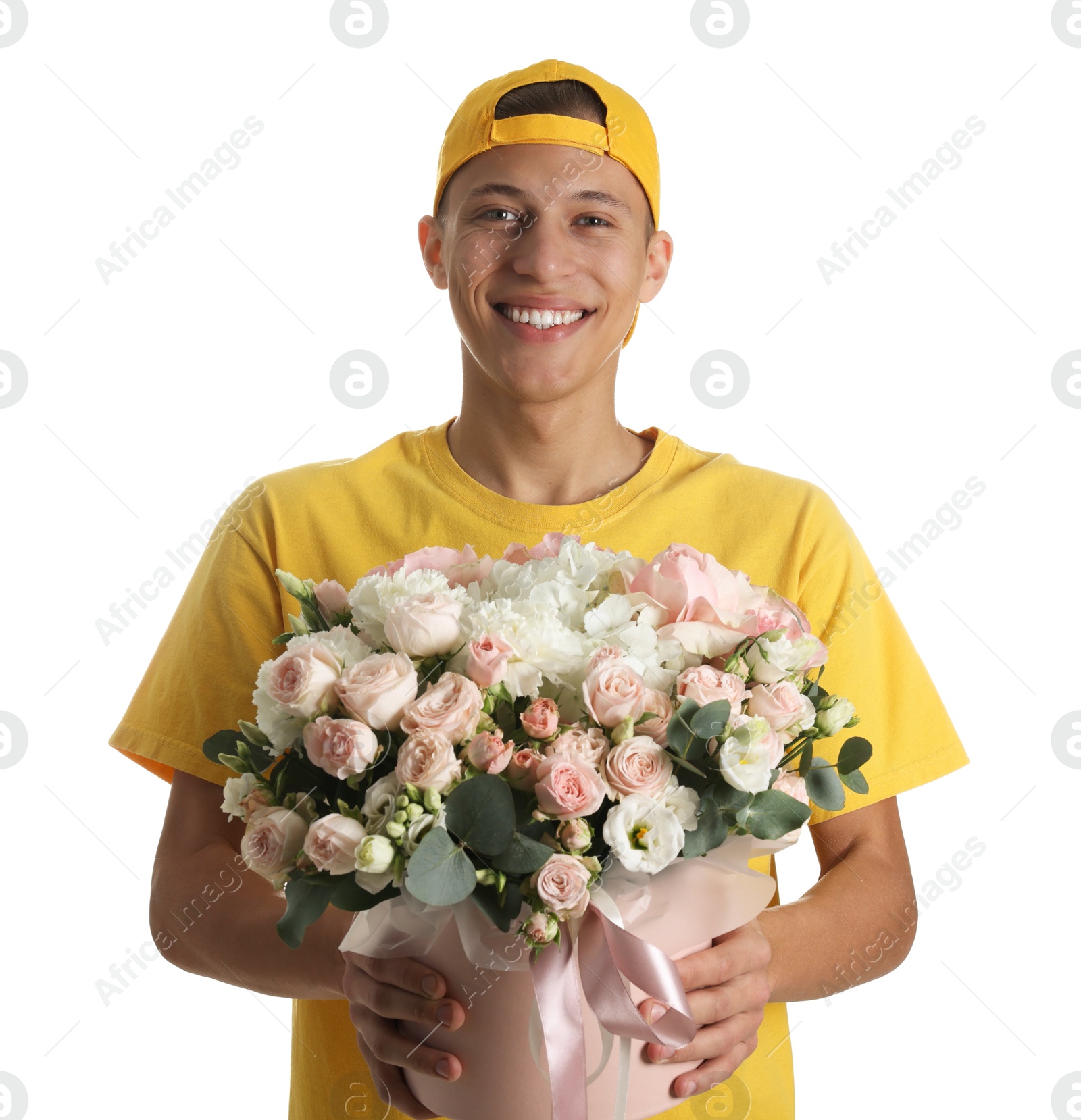 Photo of Smiling delivery man holding gift box with beautiful floral composition on white background