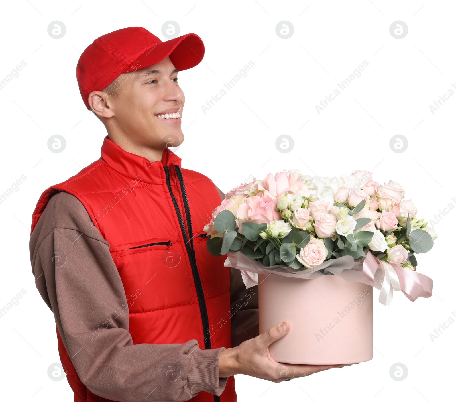 Photo of Smiling delivery man holding gift box with beautiful floral composition on white background