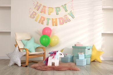 Photo of Bright pinata in shape of unicorn and party accessories in festive decorated room