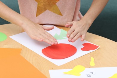 Photo of Girl making art project at table indoors, closeup