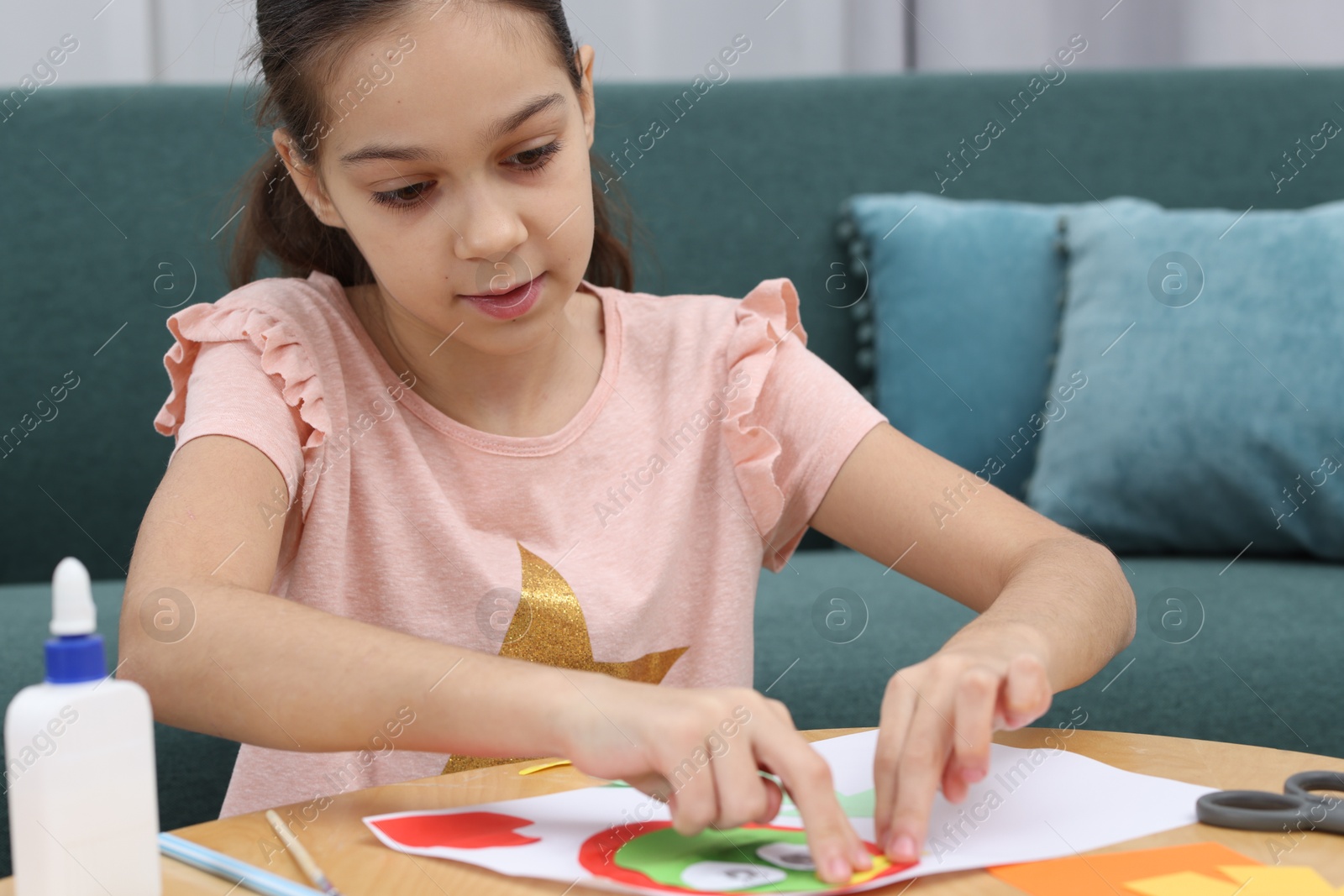 Photo of Girl making art project at table indoors