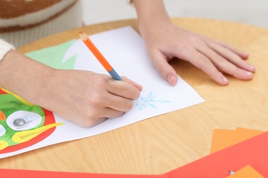 Girl drawing card at table indoors, closeup. Art and craft