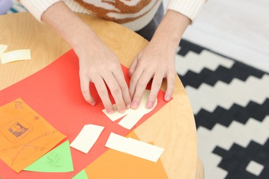 Photo of Girl making art project at table indoors, closeup