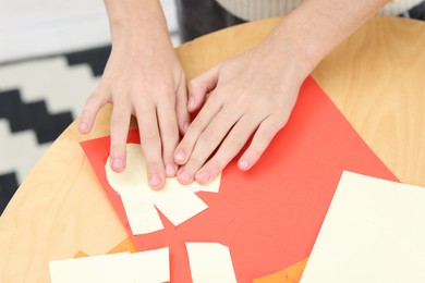 Photo of Girl making art project at table indoors, closeup