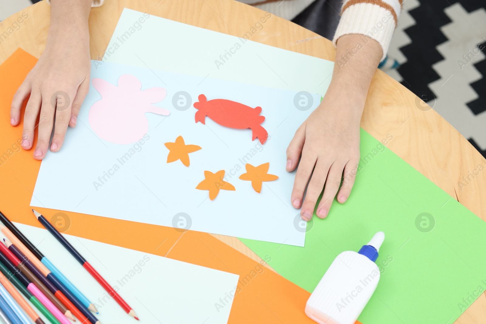 Photo of Girl making art project at table indoors, closeup