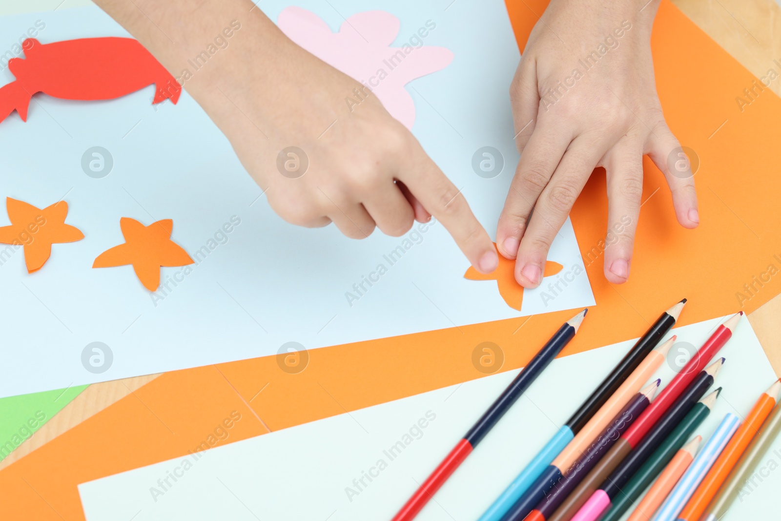 Photo of Girl making art project at table indoors, closeup