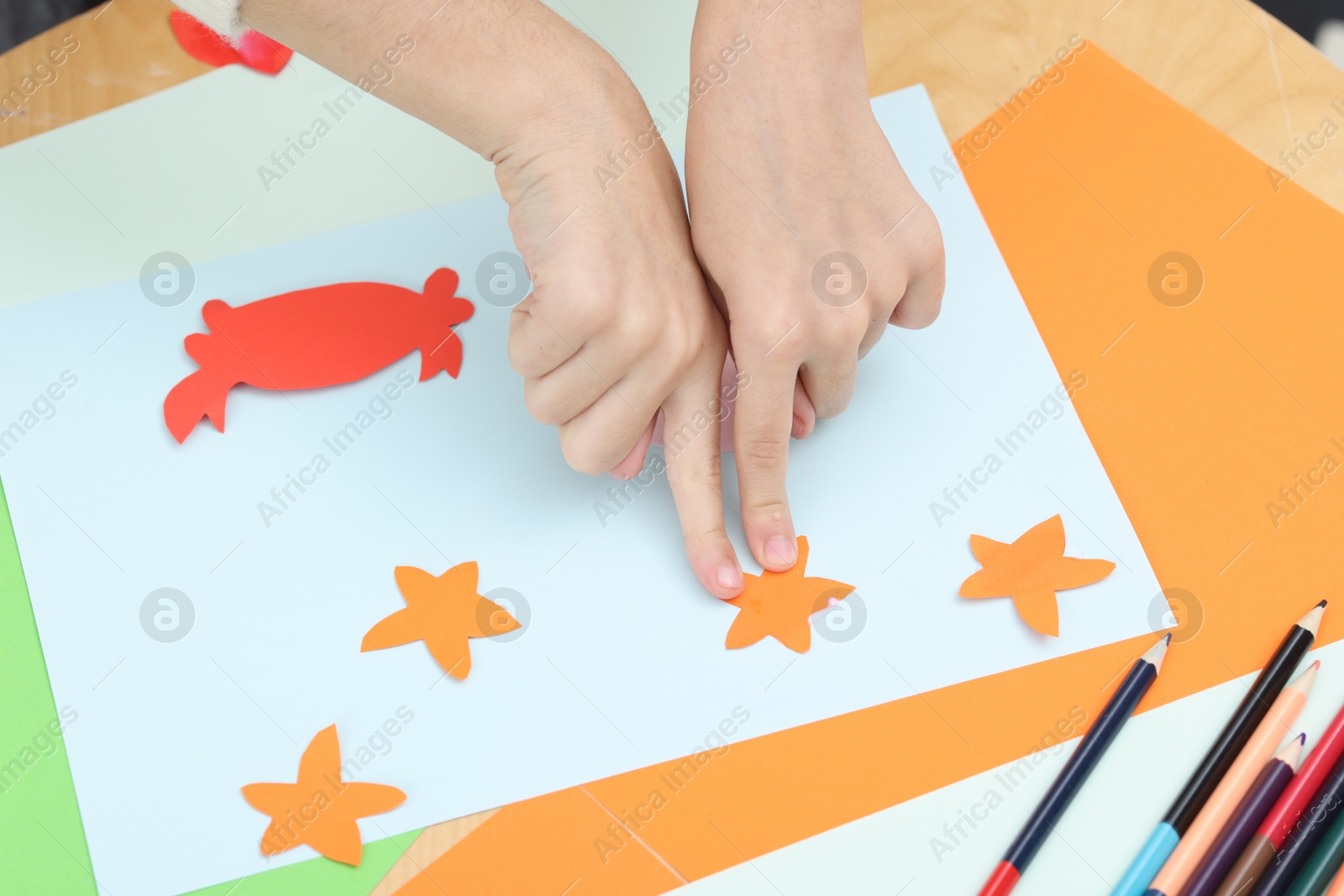 Photo of Girl making art project at table indoors, closeup