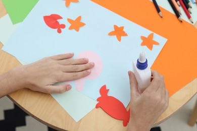 Photo of Girl making art project at table indoors, above view