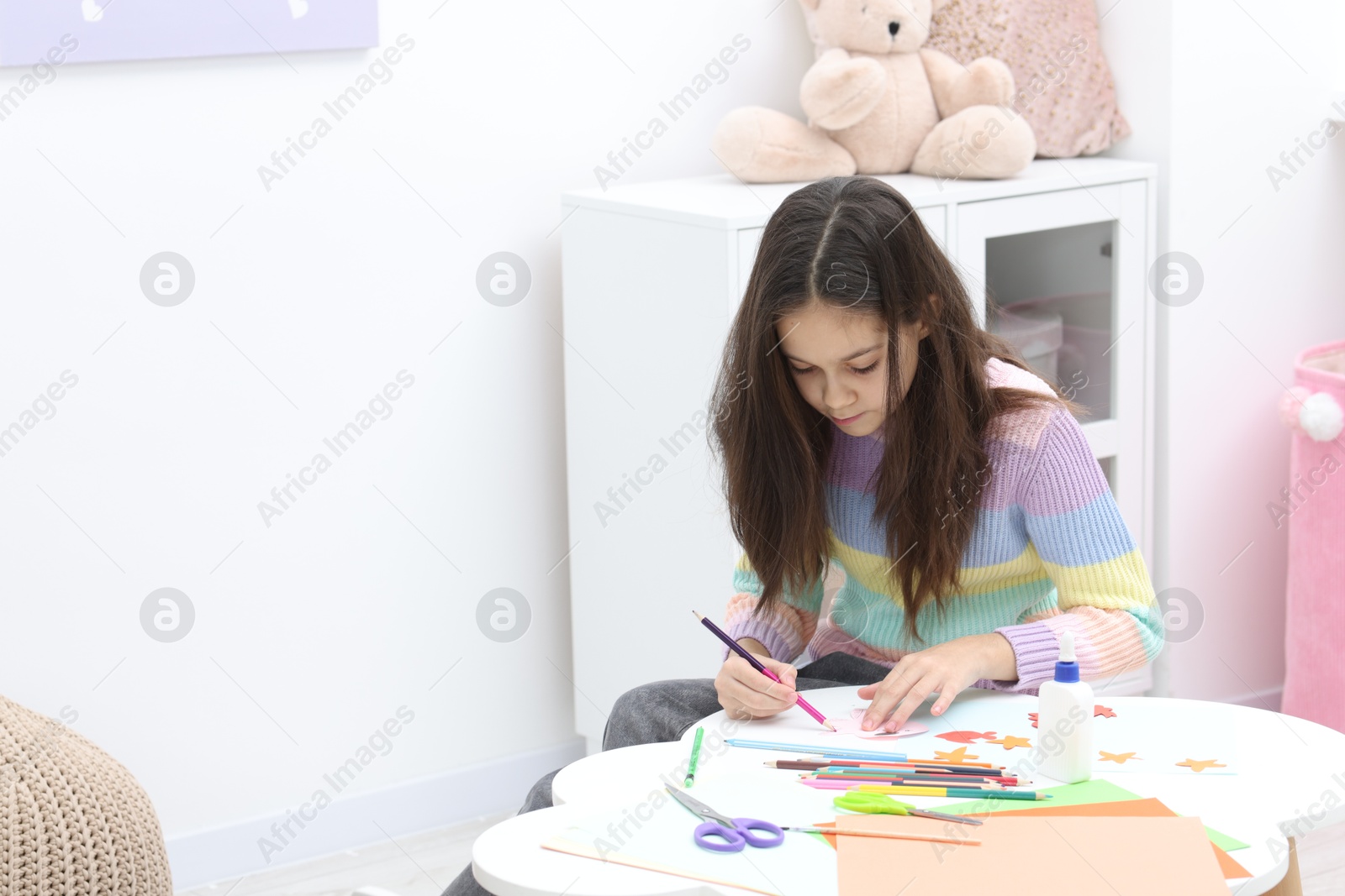 Photo of Girl drawing card at table indoors, space for text. Art and craft