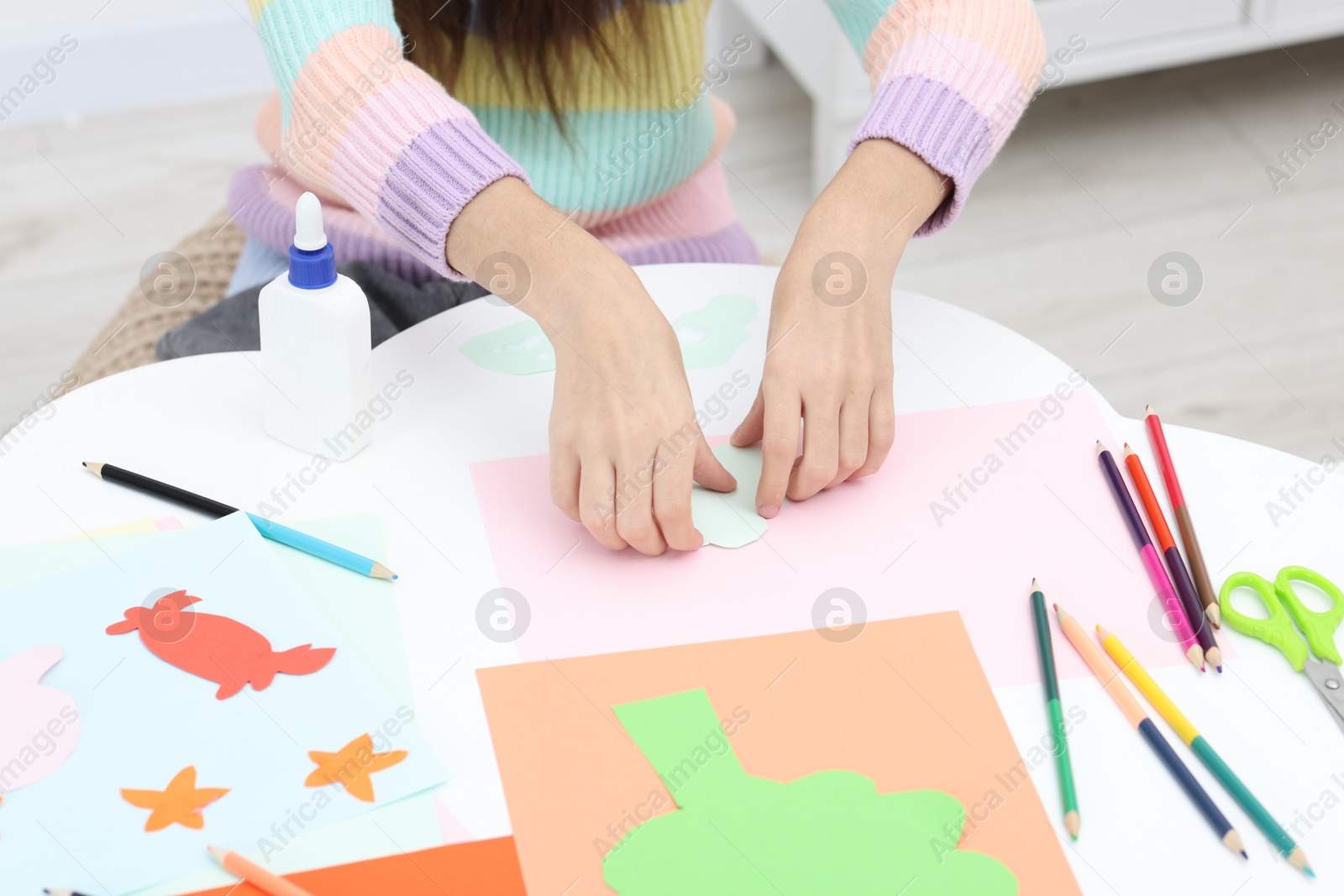 Photo of Girl making art project at table indoors, closeup