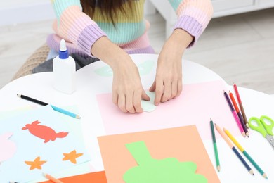 Girl making art project at table indoors, closeup