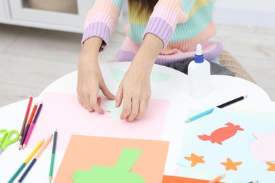 Photo of Girl making art project at table indoors, closeup