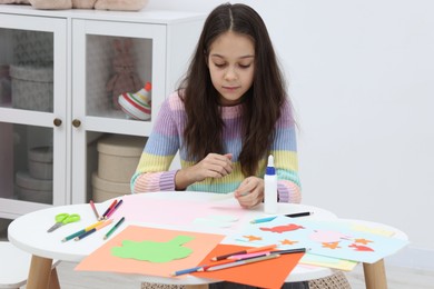 Photo of Girl making art project at table indoors