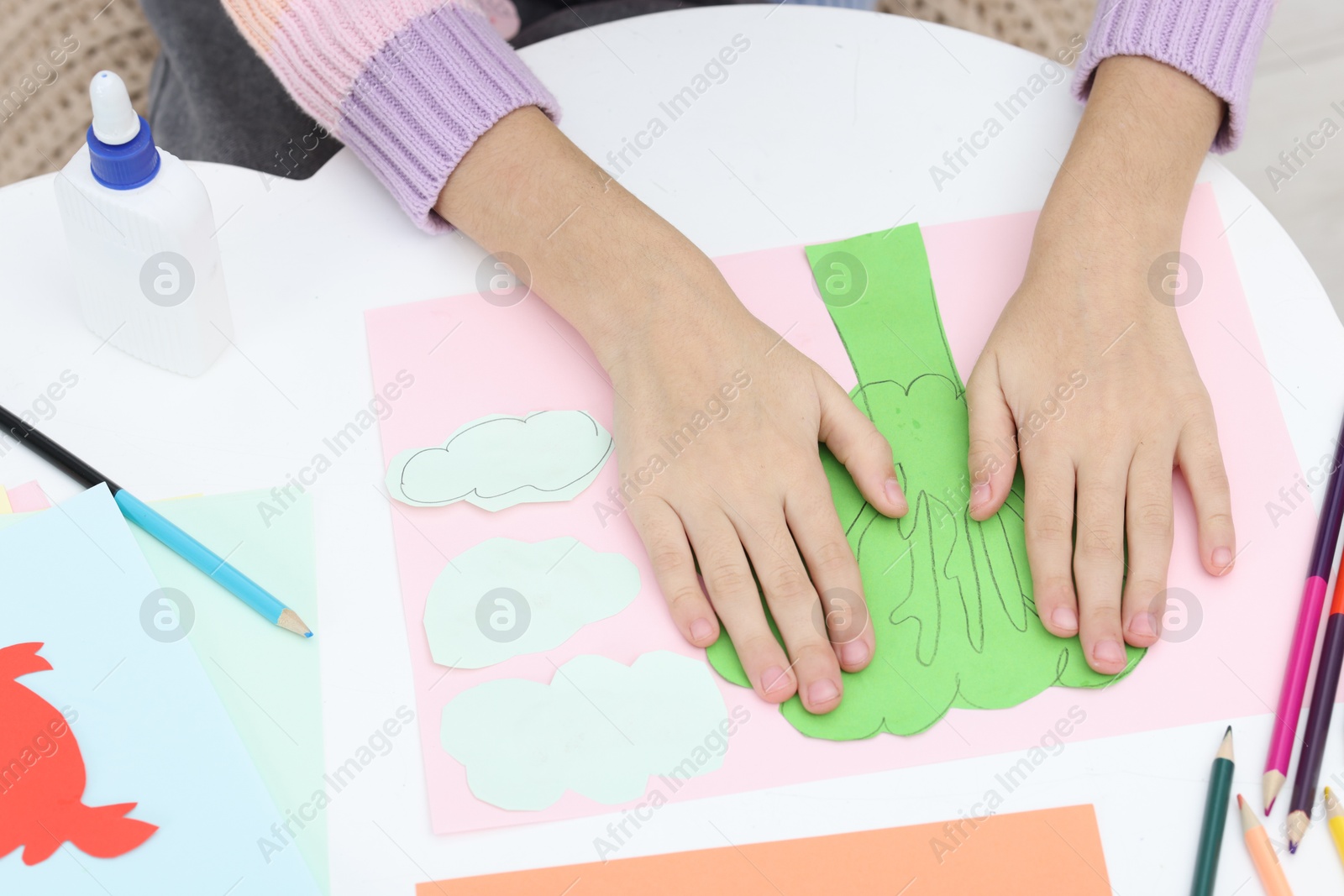 Photo of Girl making art project at table indoors, closeup