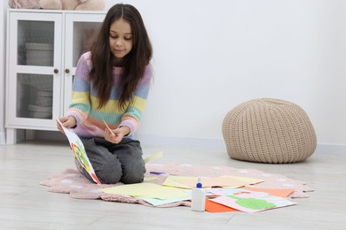 Photo of Girl making art project at home. Space for text