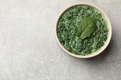 Photo of Delicious spinach sauce in bowl on grey table, top view. Space for text