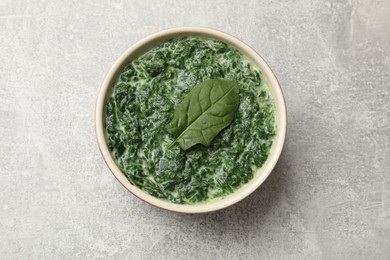 Photo of Delicious spinach sauce in bowl on grey table, top view